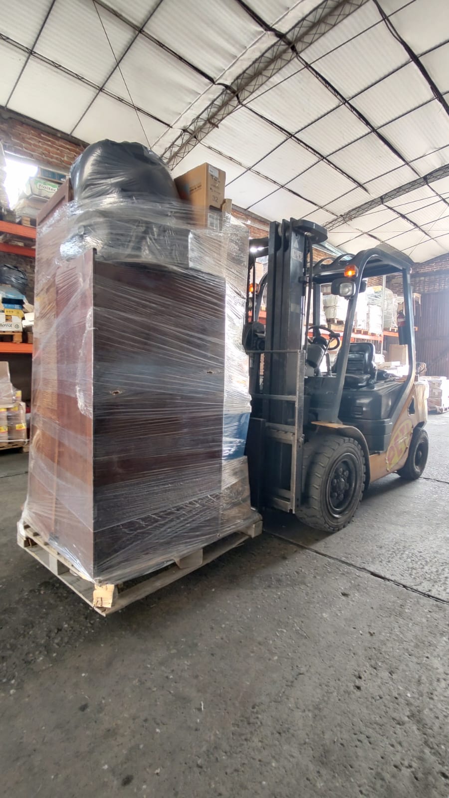 Autoelevador propio de Transporte PETI moviendo carga paletizada y filmada
